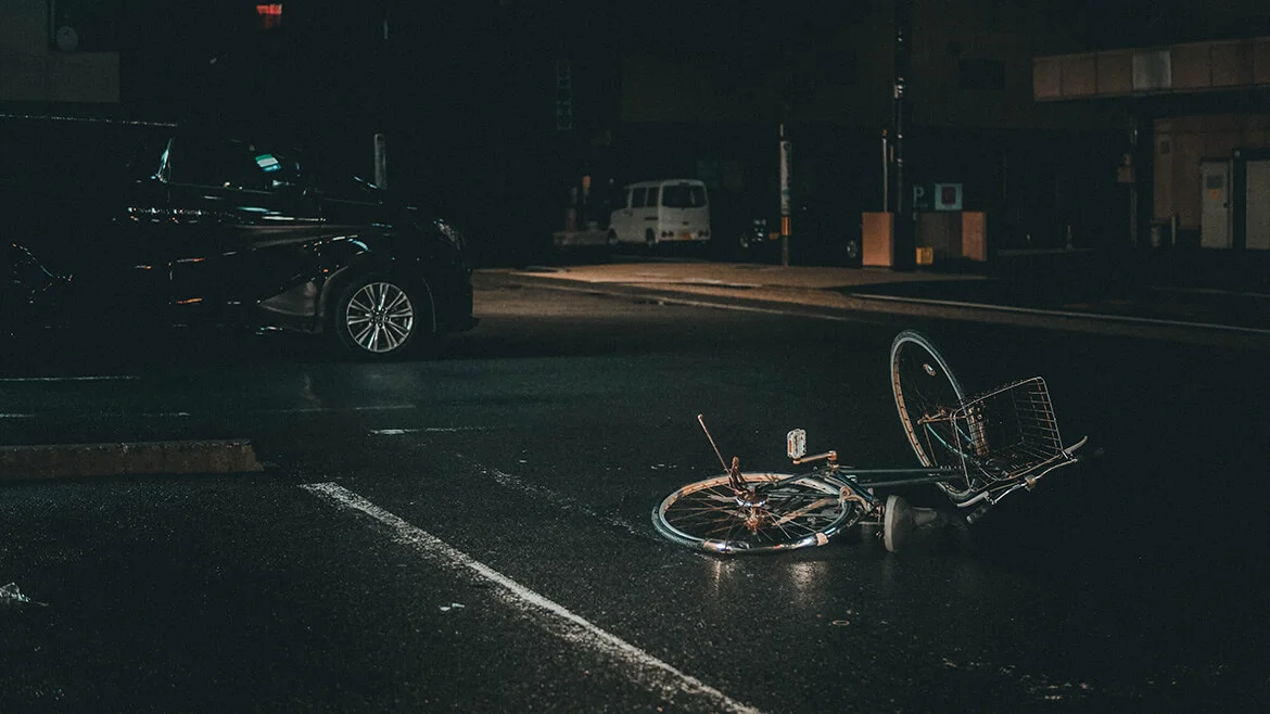 A broken bicycle lying in the middle of the road